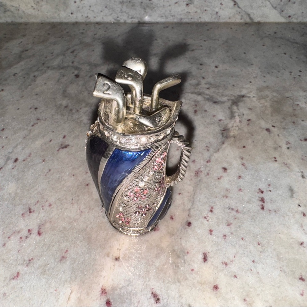 a set of golf clubs, blue and silver with pink and clear crystals trinket